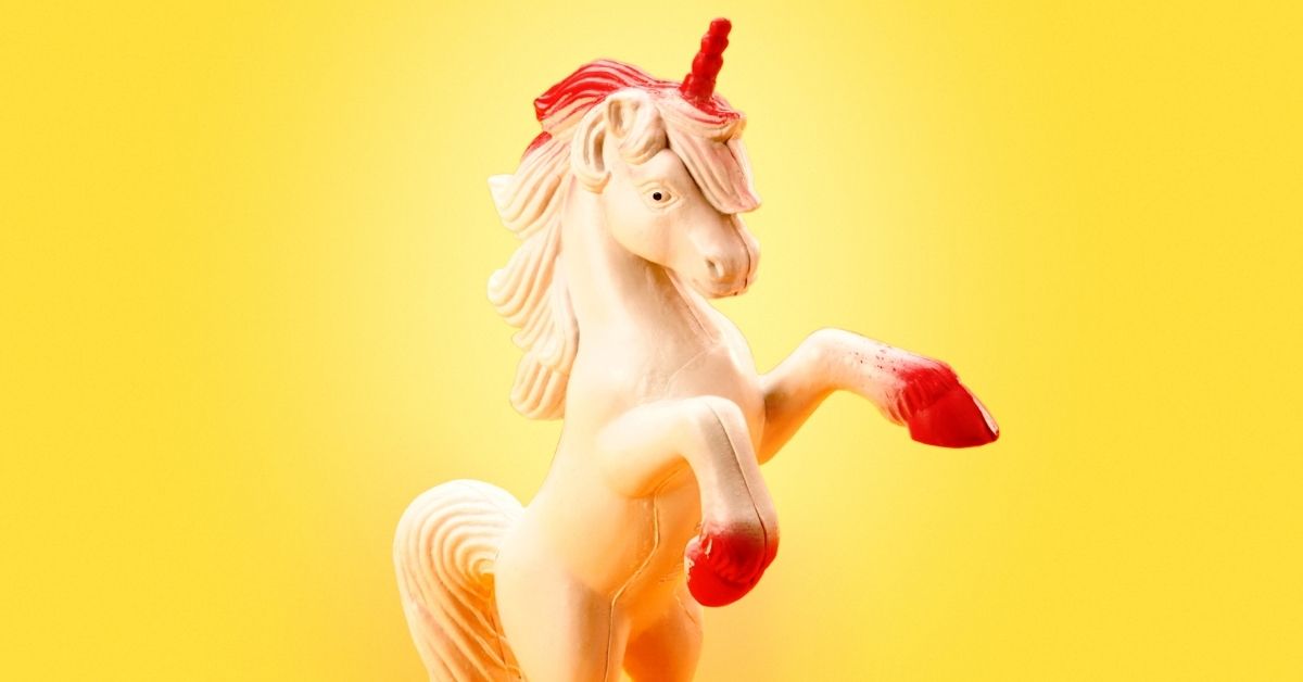 The Church of the Invisible Pink Unicorn - A Unicorn Figurine Rearing Up on a Yellow Background